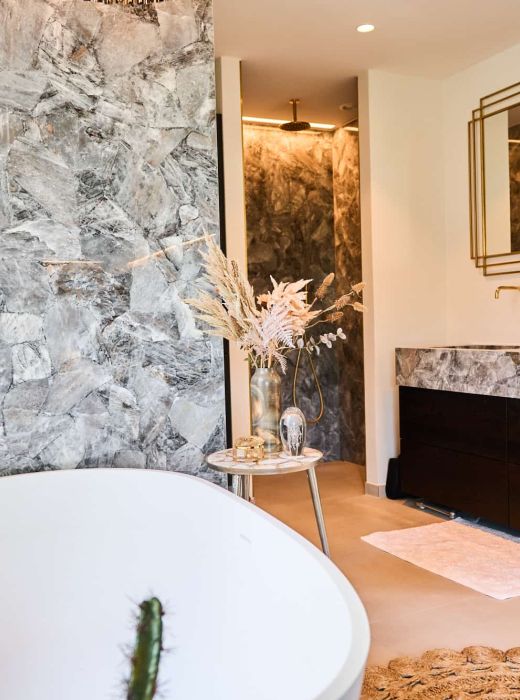 Dette badeværelse i funkishuset skiller sig ud med sine elegante guldarmaturer, der er i fokus. Det giver rummet en luksuriøs og strålende atmosfære.