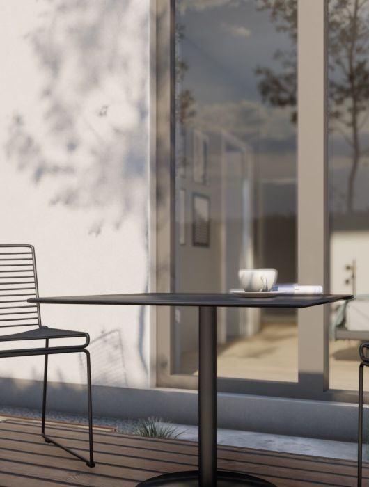 3D-model af stole og bord på en terrasse ved et funkishus.